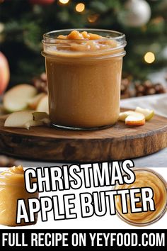 a jar of apple butter sitting on top of a wooden cutting board next to a christmas tree