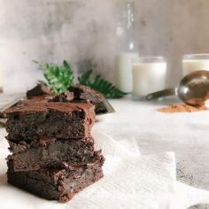 three brownies stacked on top of each other with milk and candles in the background