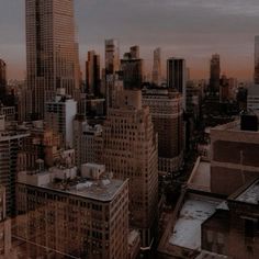 an aerial view of the city skyline at sunset or dawn, with tall buildings in the foreground