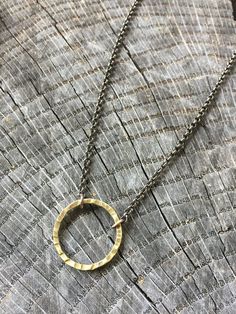 This is a neat minimalist necklace featuring a hand forged brass metalwork circle.  The black and gold pair nicely together on this simple, yet fashionable design.  Meant for guys or gals. MEASUREMENTS & SPECIFICS:PENDANT SIZE: 1"NECKLACE LENGTH: 20" FINISH: polished / lightly antiqued METAL: raw brass & blackened Stainless Steel All jewelry & wares from my studio arrive attractively packaged and ready for gifting or for keeps. All metalwork from my studio is backed by a lifetime cra Everyday Circular Brass Necklace, Minimalist Everyday Hand Forged Necklaces, Everyday Brass Necklace, Everyday Minimalist Hand Forged Necklaces, Minimalist Hammered Metal Necklaces, Minimalist Hammered Metal Necklace, Minimalist Adjustable Necklaces With Oxidized Finish, Adjustable Minimalist Necklaces With Oxidized Finish, Minimalist Adjustable Necklace With Oxidized Finish