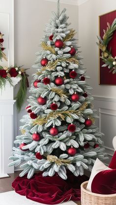 a white christmas tree with red and gold ornaments