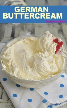 a bowl filled with whipped cream on top of a white table next to blue polka dot napkin