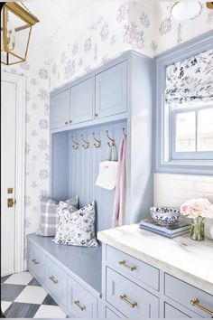 a bathroom with blue cabinets and white counter tops in front of a checkered floor