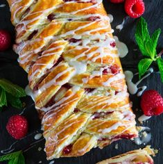 raspberry danish pastry with icing and fresh berries on the side, ready to be eaten