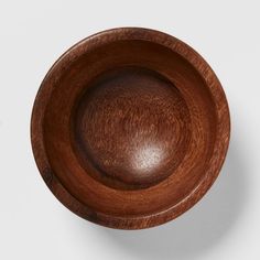 a wooden bowl is shown on a white surface