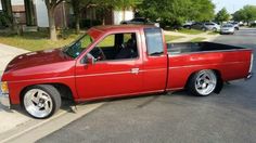 a red pick up truck parked on the side of a street