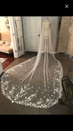 a wedding dress with a veil on the floor