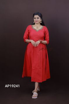 a woman in a red dress posing for the camera with her hands on her hips