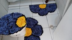 two blue and yellow rugs sitting on top of a white toilet