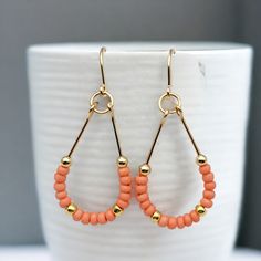 Make a statement with Lane - Gold & Coral! These 14k Gold filled teardrop hoop earrings featuring Peach coral seed beads will guarantee you some serious style points. Perfect for a fun summer night out! Approximately 1.75” long Made with 14k Gold Filled wire Glass Miyuki Seed Beads Polished to a high shine Handmade in Montana Sent in a ribboned gift box with polishing cloth Beaded Teardrop Earrings For Summer, Gold Teardrop Earrings For Summer, Summer Beaded Teardrop Earrings, Summer Teardrop Beaded Earrings, Nickel Free Teardrop Earrings For Summer, Summer Teardrop Earrings With Ear Wire, Teardrop Hoop Earrings, Wired Glass, Open Hoop Earrings