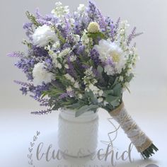 a bouquet of white and purple flowers in a vase