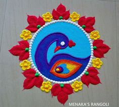 a colorful peacock design on a white surface with red and yellow flowers in the center