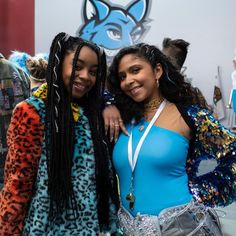 two women dressed in costumes posing for the camera with their arms around each other and smiling