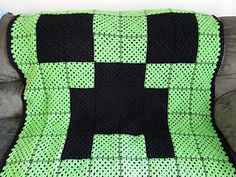 a green and black blanket sitting on top of a couch