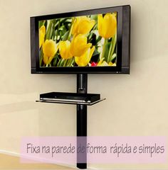 a flat screen tv mounted to the side of a wall next to a black stand