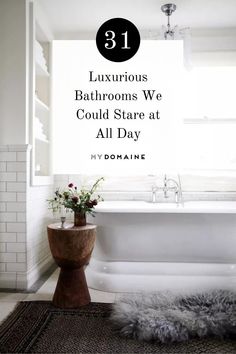 a white bath tub sitting under a window next to a rug