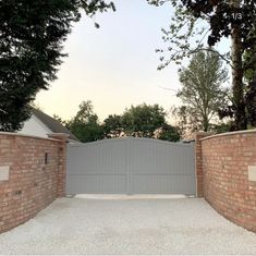 a brick fence and gate with trees in the background