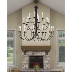 a chandelier hanging from the ceiling in a living room with fireplace and windows