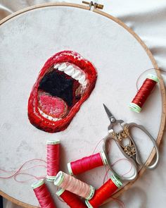 an embroidery project with scissors, thread and spools of thread on the table