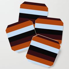 three brown and blue striped coasters sitting on top of each other in front of a white background