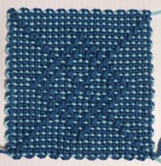 a close up of a blue and white piece of cloth with yarn on the side