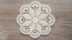 a crocheted doily on a wooden surface