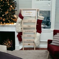 stockings are hanging on a rack in front of a christmas tree