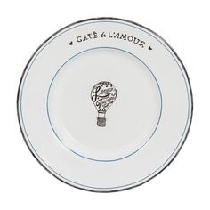 a white plate with a hot air balloon on the rim that says cafe & lampur