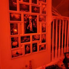 there is a wall with pictures on it in the corner and an orange light shining through