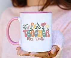 a woman holding a coffee mug with the words teacher mrs smith written in floral letters