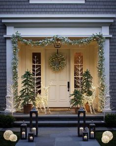 front door decorated for christmas with lighted trees and wreaths