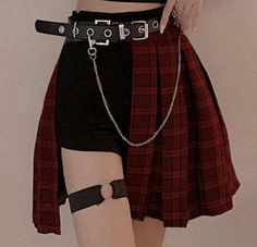 a woman in black and red is wearing a skirt with chains attached to her waist