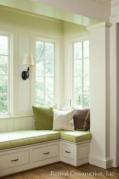 a corner window seat with pillows on it