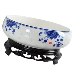 a blue and white bowl sitting on top of a black stand