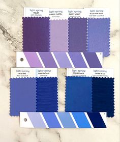 several shades of blue and purple on a marble surface with the same color swatches