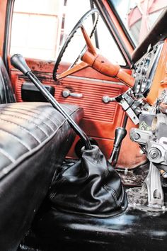 the interior of an old car with leather seats and steering wheel, including a clock