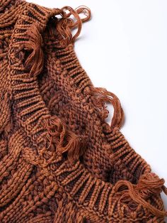 a brown knitted scarf laying on top of a white table