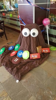 a chocolate covered object with eyes and googly eyes on it's face sitting in front of a display case