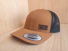 Celebrate Dad with the perfect personalized gift! These leather patch hats are made with high quality leatherette and premium, adjustable snapback, 6 panel, structured trucker hats! Dad will love this hat! ►►Want to have a name besides DAD on your hat? No problem! Enter any name you'd like into the personalization box. The perfect gift for Pops, Grandpa, Papa, Poppy, etc! *Shown in photo: → Hat Color: Caramel/Black → Patch Color: Rawhide ►THE DETAILS: → Premium 6 Panel Trucker Snapback Hat → Fab Dad Pregnancy Announcement, Hat Fabric, Leather Patch Hat, Patch Hats, Birthday Gift For Dad, Black Patch, Patch Hat, Christmas Gift For Dad, Dad Birthday Gift