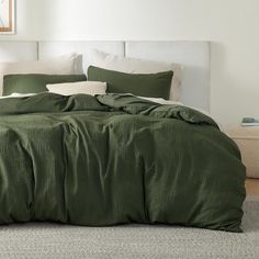 a bed with green sheets and pillows in a room