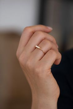 a woman's hand with a gold ring on it