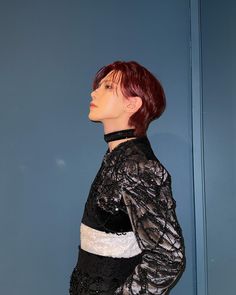 a mannequin is standing in front of a blue wall wearing a black and white top