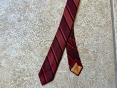 "Here is a vintage necktie from \"Lou Dramin,\" that can be dated to the 1960s. Made of 100% silk, it features a regimental block stripe of red & black. CONDITION: Excellent vintage condition, with no notable flaws. MEASUREMENTS: -Total length: 55\" -Width at widest point: a hair under 2\"" Vintage Brown Ties For Formal Occasions, Vintage Formal Ties, Vintage Standard Business Tie, Vintage Business Ties, Vintage Business Tie, Vintage Red Suit And Tie Accessories For Formal Occasions, Red Vintage Suit And Tie Accessories For Formal Occasions, Vintage Black Tie Accessories, Vintage Suit And Tie Accessories For Black Tie