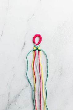 the colorful string is hanging on the marble counter top, and it's attached with a loop