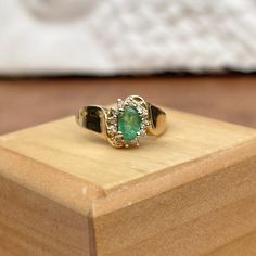 Estate/ vintage 14KT yellow gold concave band ring with oval, genuine emerald + diamond accents in a halo setting. Nicely saturated, medium green emerald in a vintage concave style band. Size 6.25 Weight: 3.00 grams Genuine, oval-cut emerald measures: 5mm x 4mm .65 carat Emerald Halo of round, natural diamonds= .12 CTW I'1 clarity; G color diamonds Stamped 14K Excellent estate condition Heirloom Oval Cabochon Emerald Ring, Oval Emerald Ring With Diamond Accents For May Birthstone, Vintage Green Diamond Ring With Halo Setting, Green Vintage Diamond Ring With Halo Setting, Green Diamond Ring With Halo Setting In Vintage Style, Heirloom Oval Emerald Ring As May Birthstone, Vintage Oval Emerald Ring With Diamond, Vintage Emerald Ring With Halo Setting For May Birthstone, Heirloom Oval Green Emerald Ring