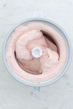 a food processor filled with pink frosting on top of a counter