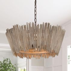 a wooden chandelier hanging from a ceiling in a room with white walls and windows