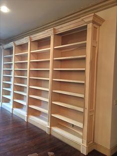 empty bookshelves in an empty room with hard wood floors