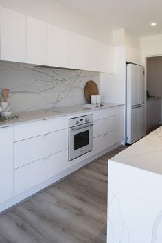 Fresh white kitchen with white marble splashback and countertop. Marble Look Splashback Kitchen, White Kitchen Bench, Kitchen Aesthetic Ideas, White Kitchen Aesthetic, Split Level Home Designs, Bright White Kitchen, Montgomery Homes