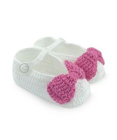 a pair of crocheted baby shoes with pink bows on the front and bottom